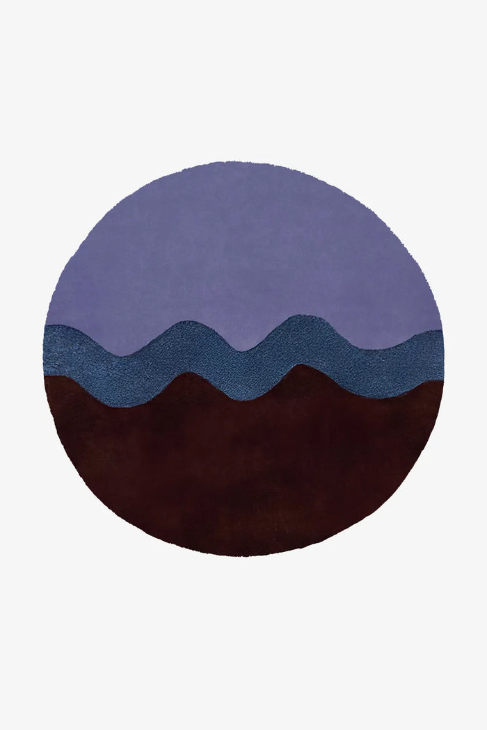 Round modern wool rug in 8x8 size with flowing wavy stripe design in purple, navy, and dark brown