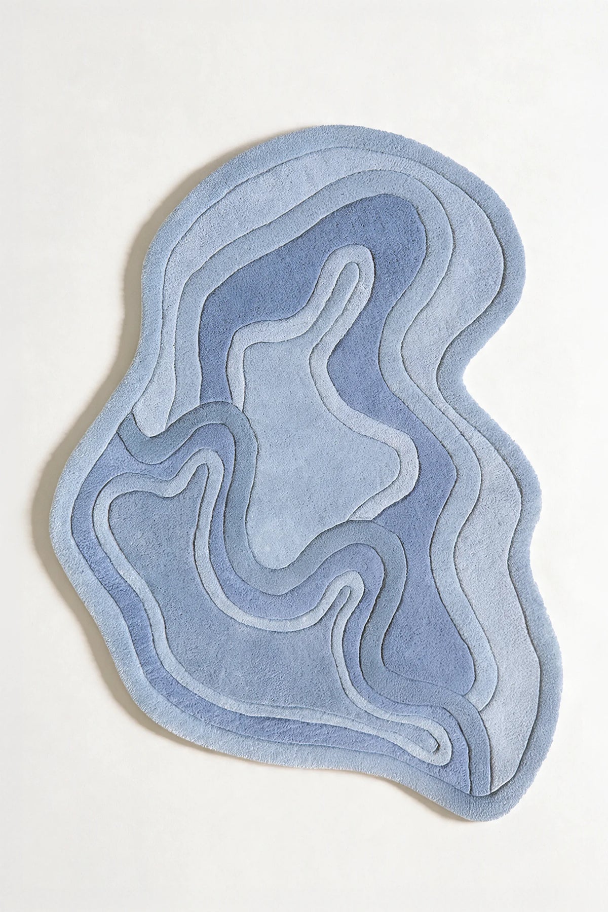Blue asymmetrical rug with flowing lines, styled as a modern 6x9 area rug, coastal rug, or funky custom size wool rug