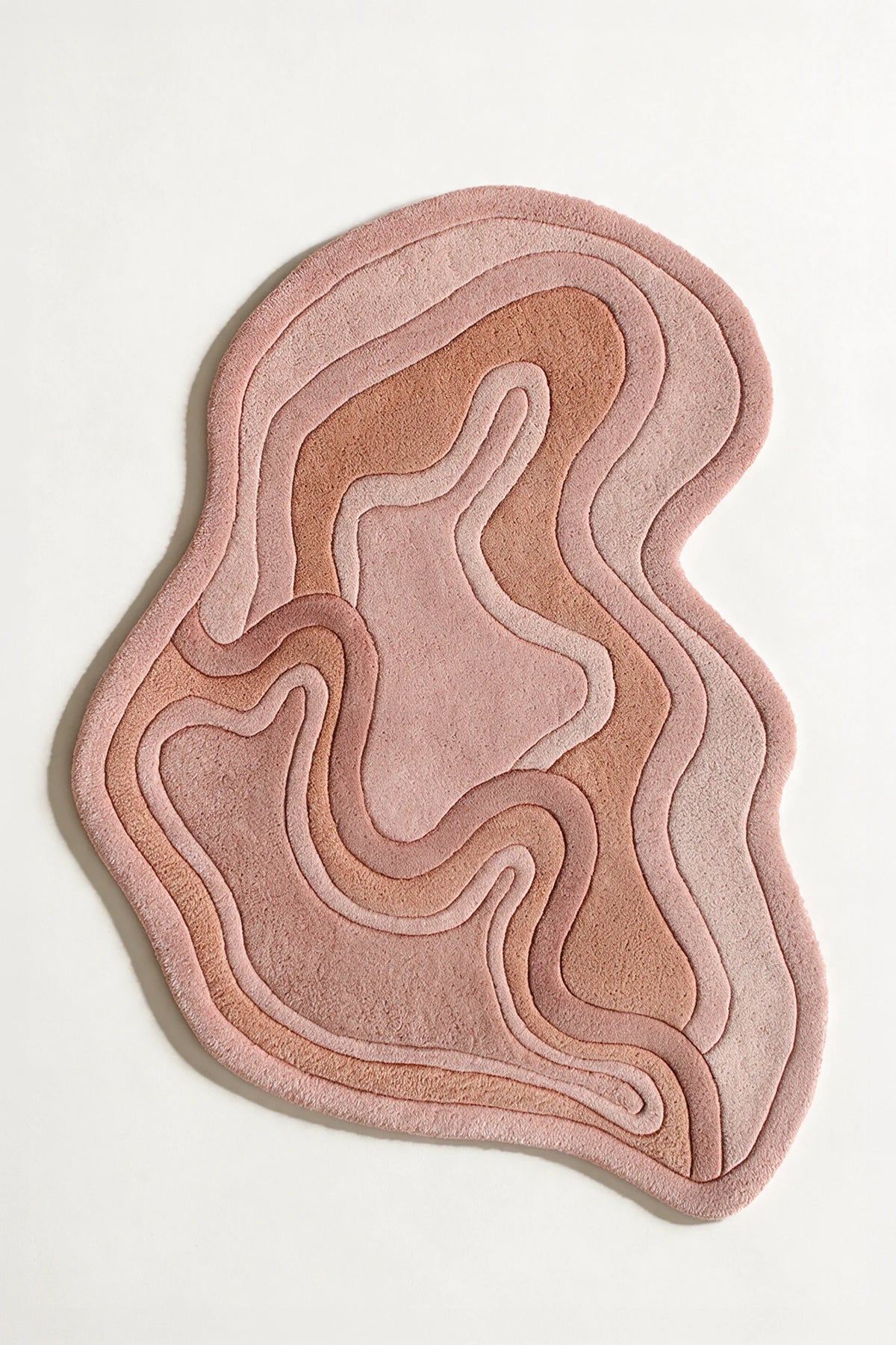 Rust colored abstract shape rug with wavy edge, suited for boho rugs, 5x7 wool area rugs, or custom rugs for bedroom and entryway