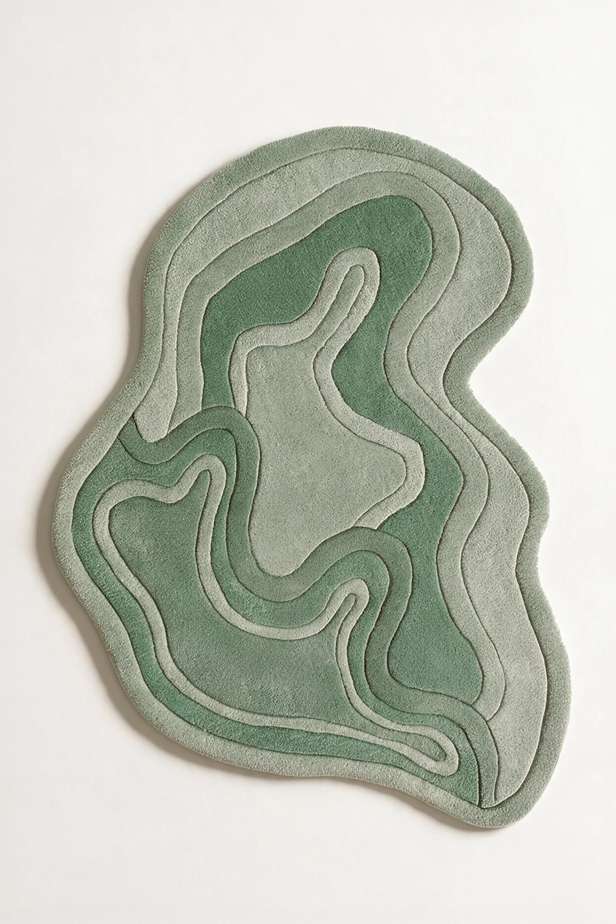 Sage green irregular rug with fluid contours, perfect as a modern wool rug for living room, kids area rug, or boutique neutral area rug