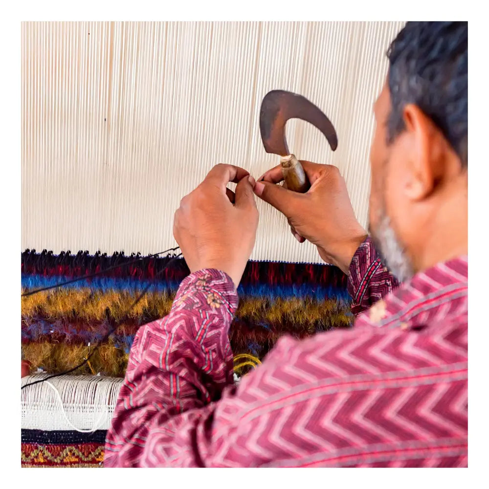 Artisan crafting a handmade wool rug from dyed yarns, highlighting Jubi’s custom rug process