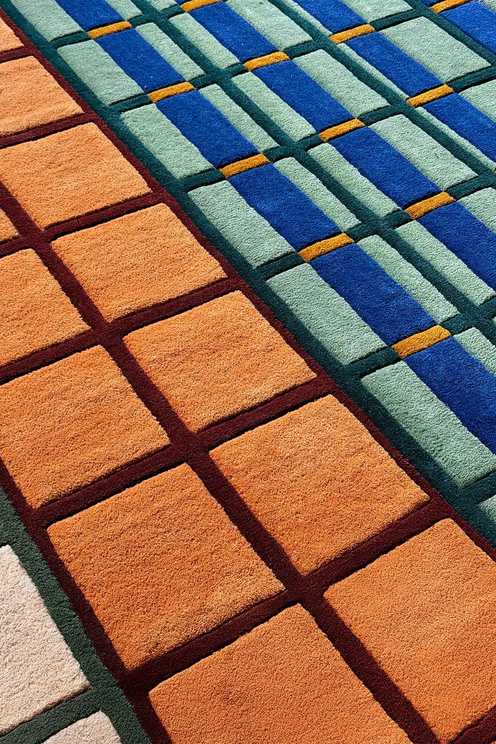 Colorful tufted wool rug with sculpted squares in blue, green, and terracotta, ideal for bold living rooms
