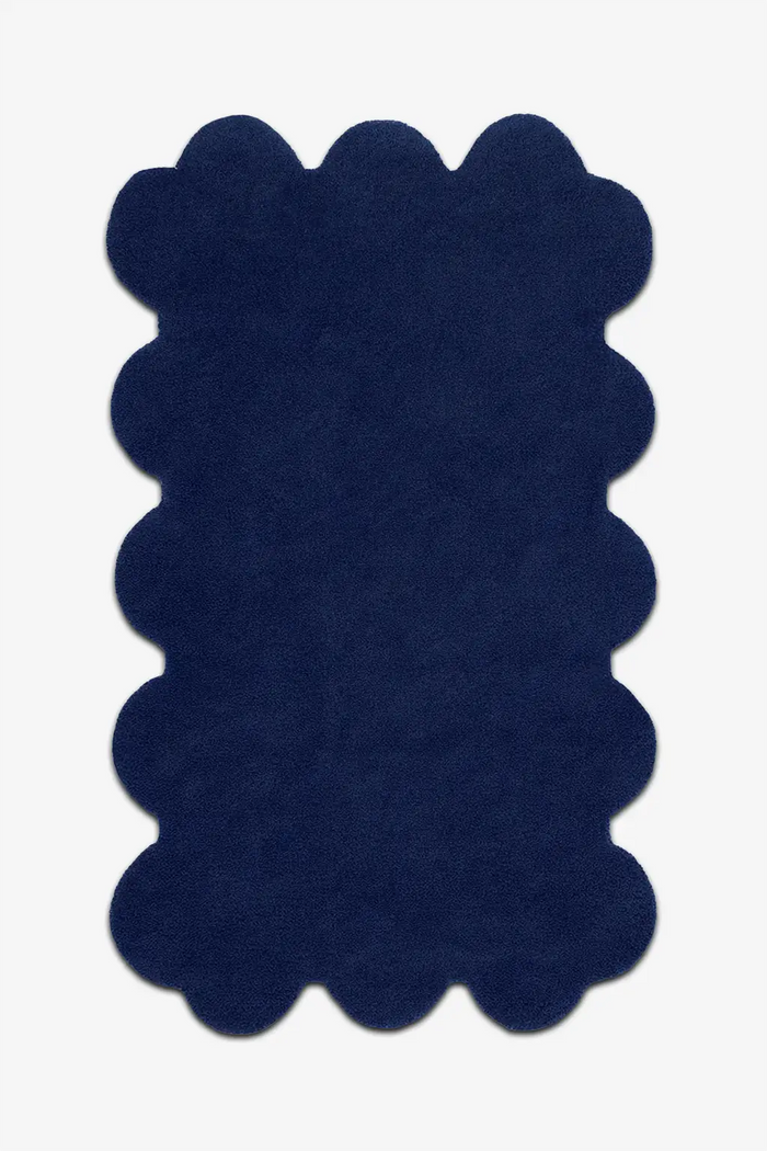 Modern navy blue scalloped rug with soft wool pile and bold sculpted edges, ideal for moody interiors