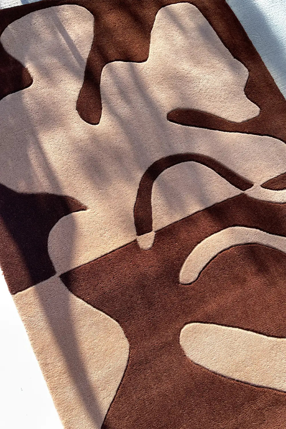 Close-up of textured abstract rug in deep brown and warm beige