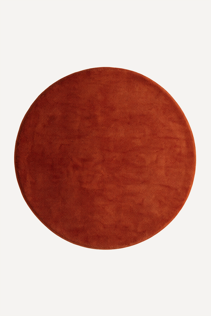 large burnt orange round wool rug in earthy tones, available in 9x9 and 8x8 sizes