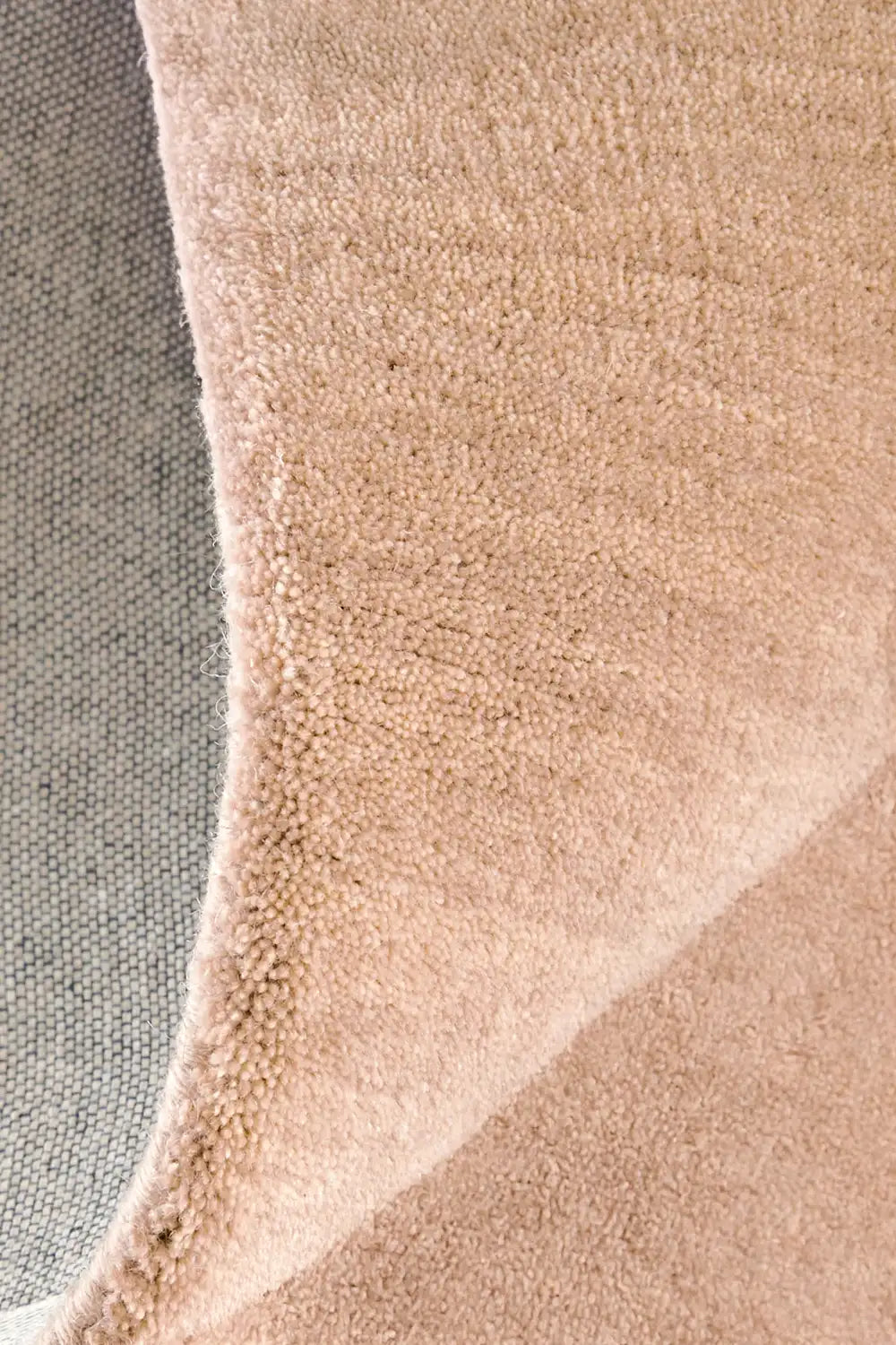 Close-up of tan and brown wool pile showing the hand-tufted craftsmanship and soft color variation for natural modern spaces