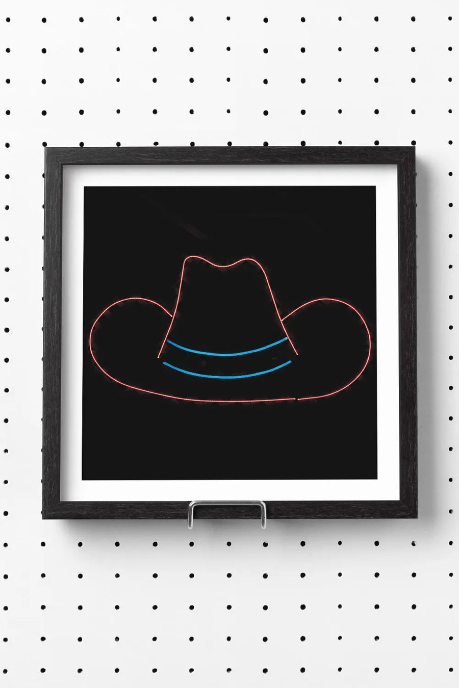 Neon cowboy hat sign glowing red and blue against a black background