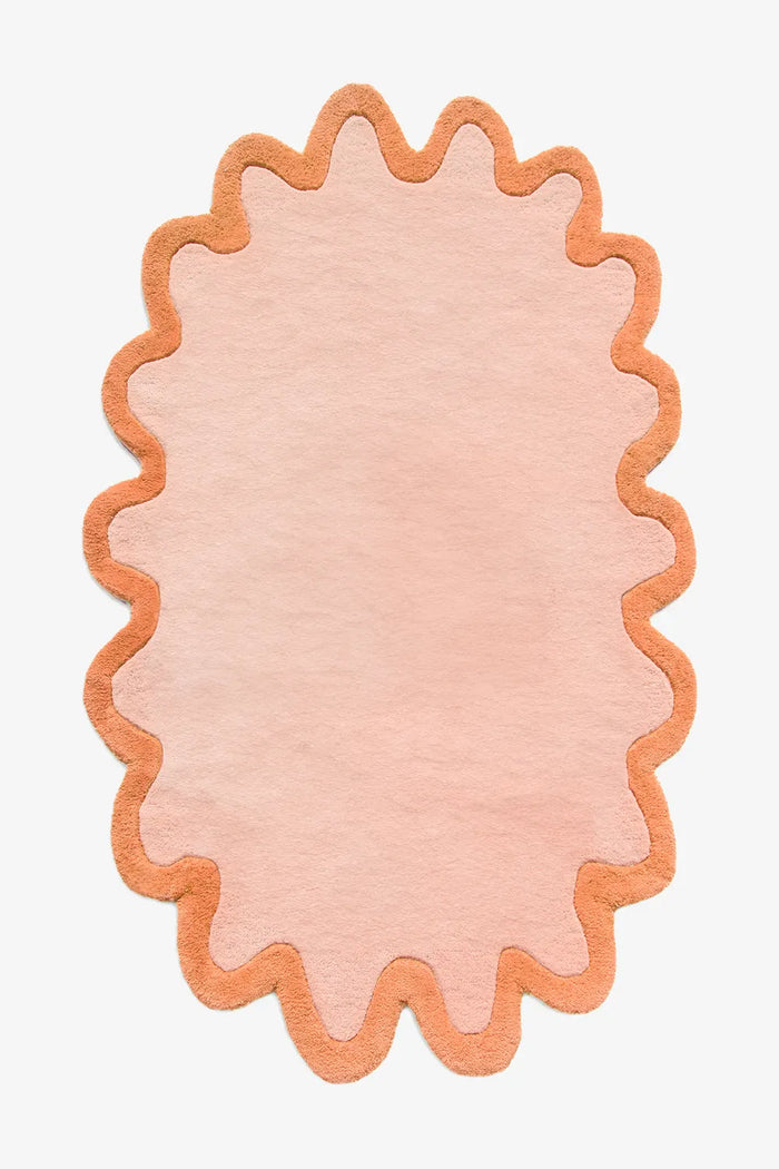 Modern peach round wool rug with orange scalloped border, available in 5x8 and 8x10