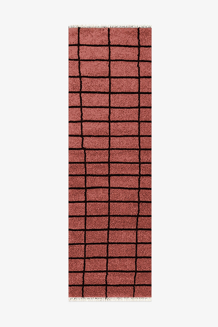 burnt orange runner rug with a grid pattern on a white background