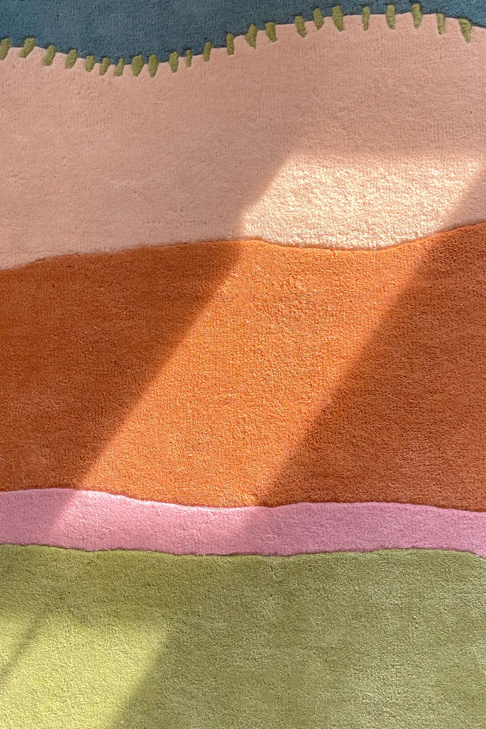 Detail of vibrant striped area rug with raised texture and tropical tones