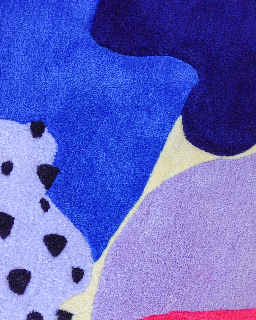 Zoomed-in view of modern round rug with layered abstract pattern in saturated tones