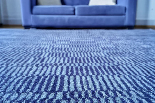 blue and navy striped wool modern area rug in a bright eclectic living room
