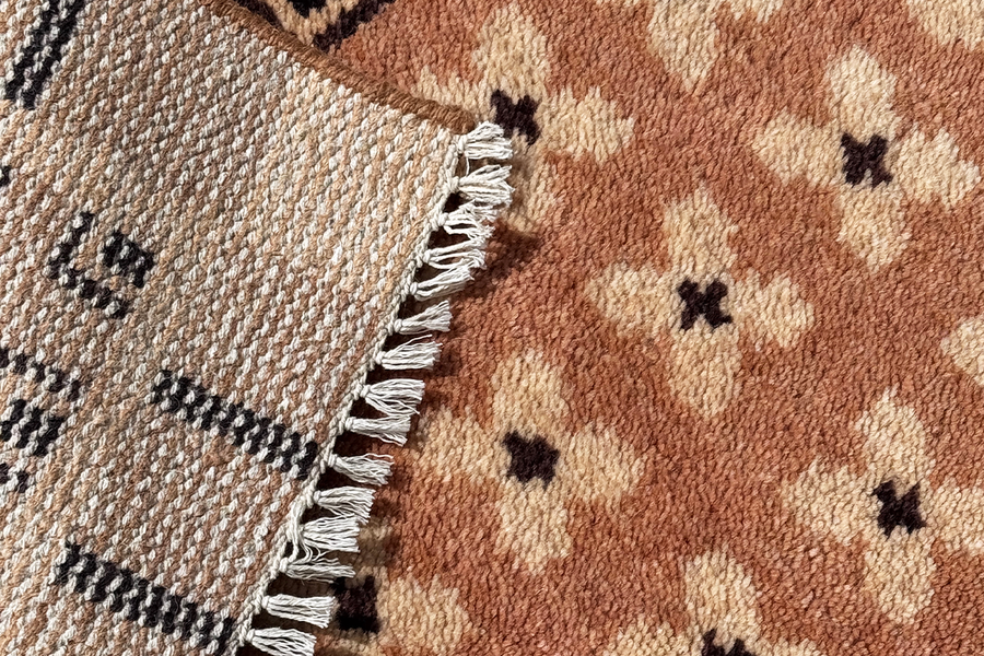 close-up detail of knot density in a modern hand-knotted wool rug in neutral geometric pattern with fringe