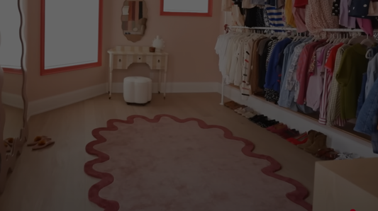 dream closet makeover featuring the Halo Burst Oval Tufted Rug in soft pink with a deep rose scalloped border, adding warmth and texture to the stylish dressing space