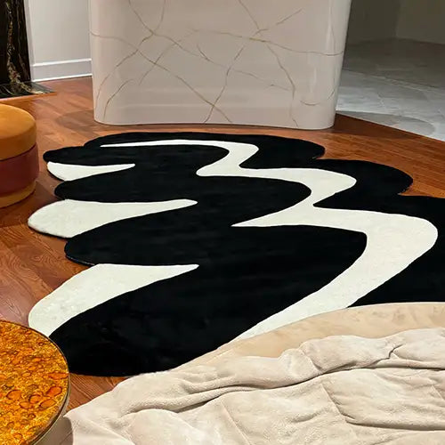 Abstract black and white area rug in 8x10 size under curved modern sofa