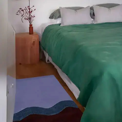 purple wool rug alongside a modern bed