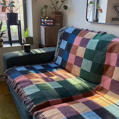 colorful woven throw blanket draped over a modern couch.