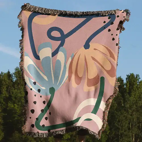pink cotton woven throw blanket with abstract floral pattern