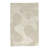 A neutral-toned abstract floral rug in cream and ivory, offering a subtle, sculptural pattern.