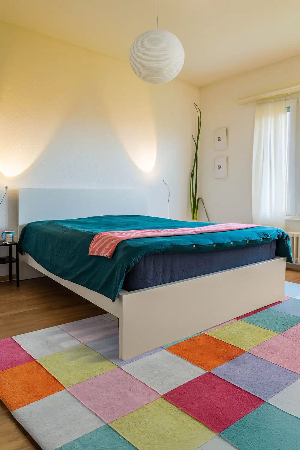 Pastel pink blue orange and white checkered rug in a cozy bedroom setting