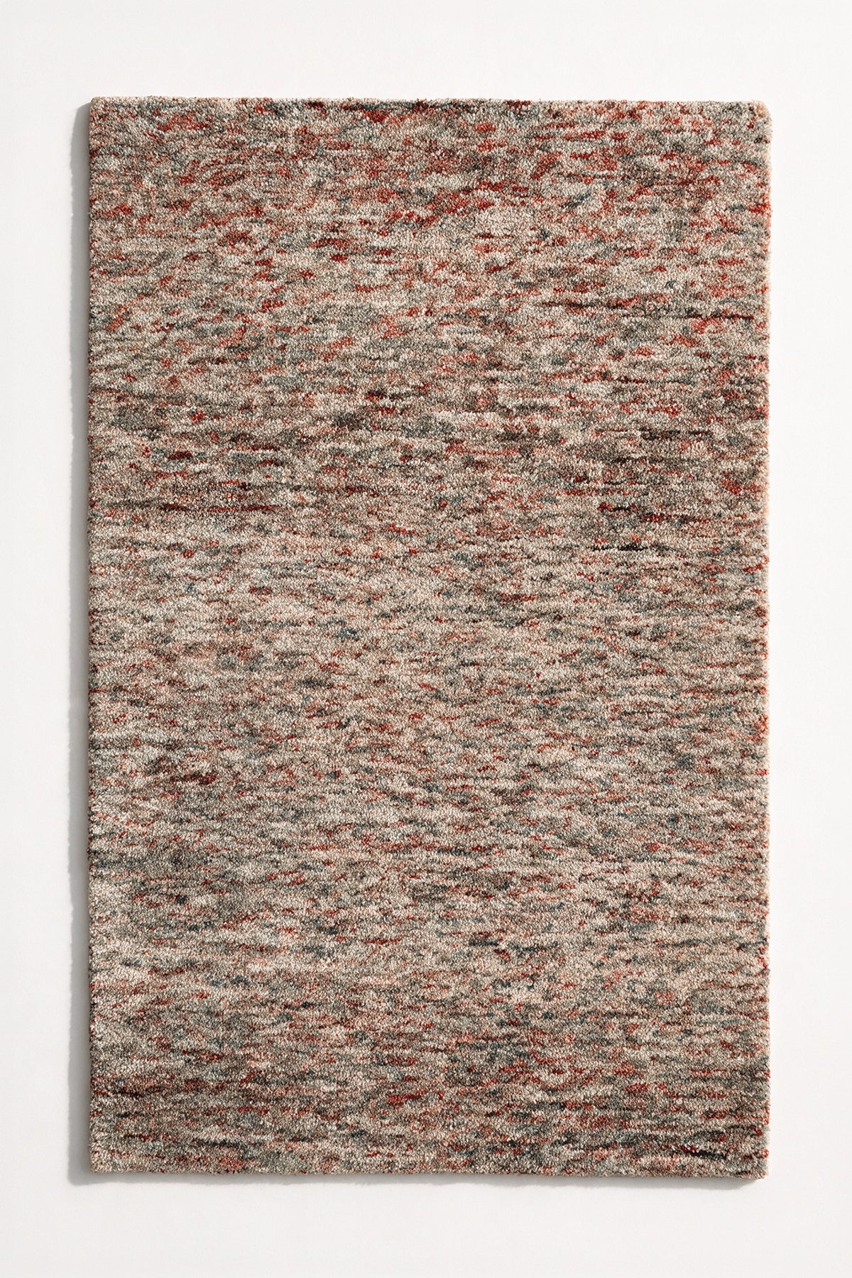 a canyon hand-tufted wool rug with heathered rust, grey and cream flecks shown from above