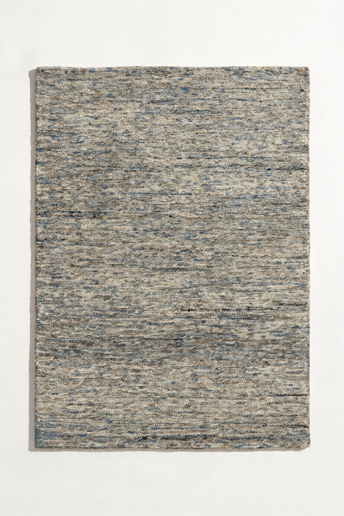 a flint hand-tufted wool rug with heathered grey, blue and sand flecks shown from above