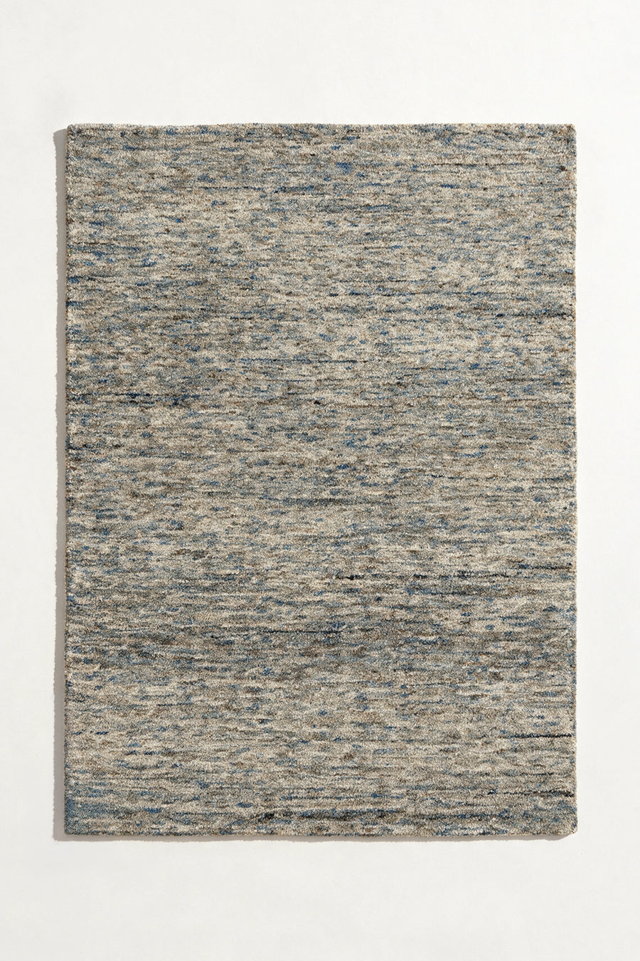 a flint hand-tufted wool rug with heathered grey, blue and sand flecks shown from above