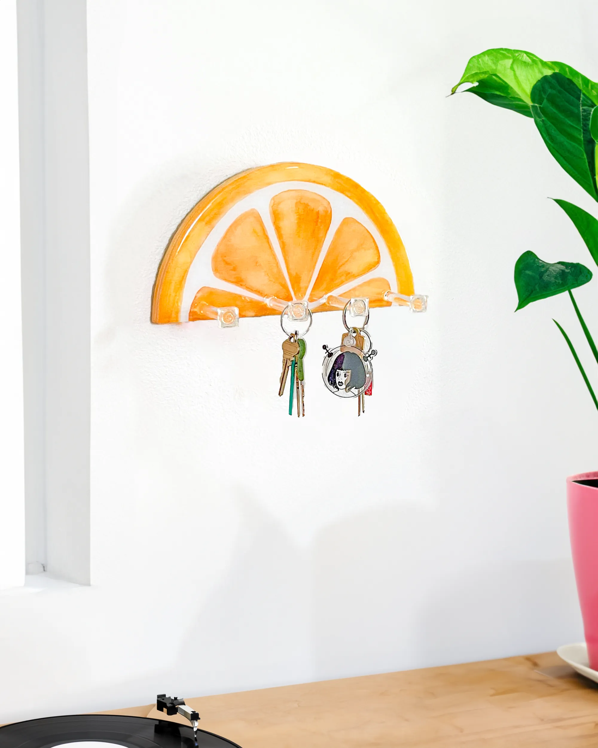 Wall-mounted orange slice key holder, demonstrating its use for organizing keys and small accessories