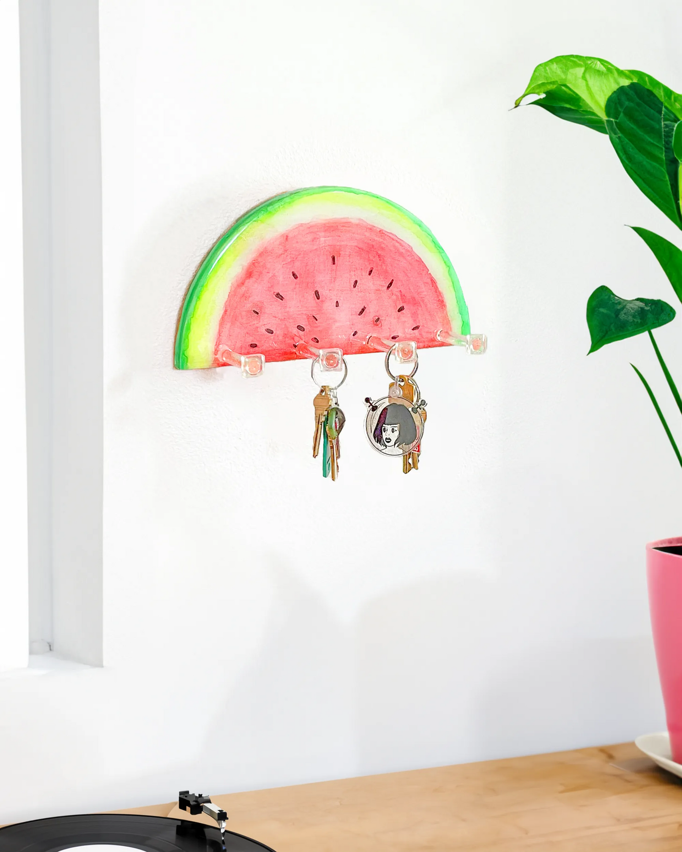 Hand-painted watermelon slice key holder with vibrant red and green colors on a wooden base