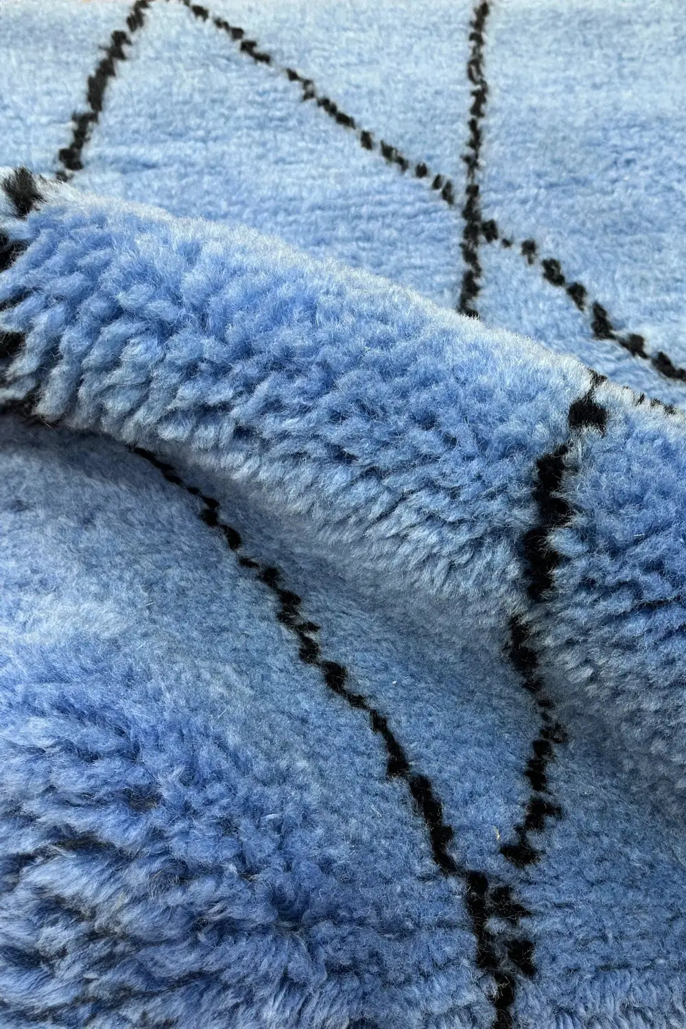 Royal blue shag rug with a Moroccan-inspired diamond pattern.