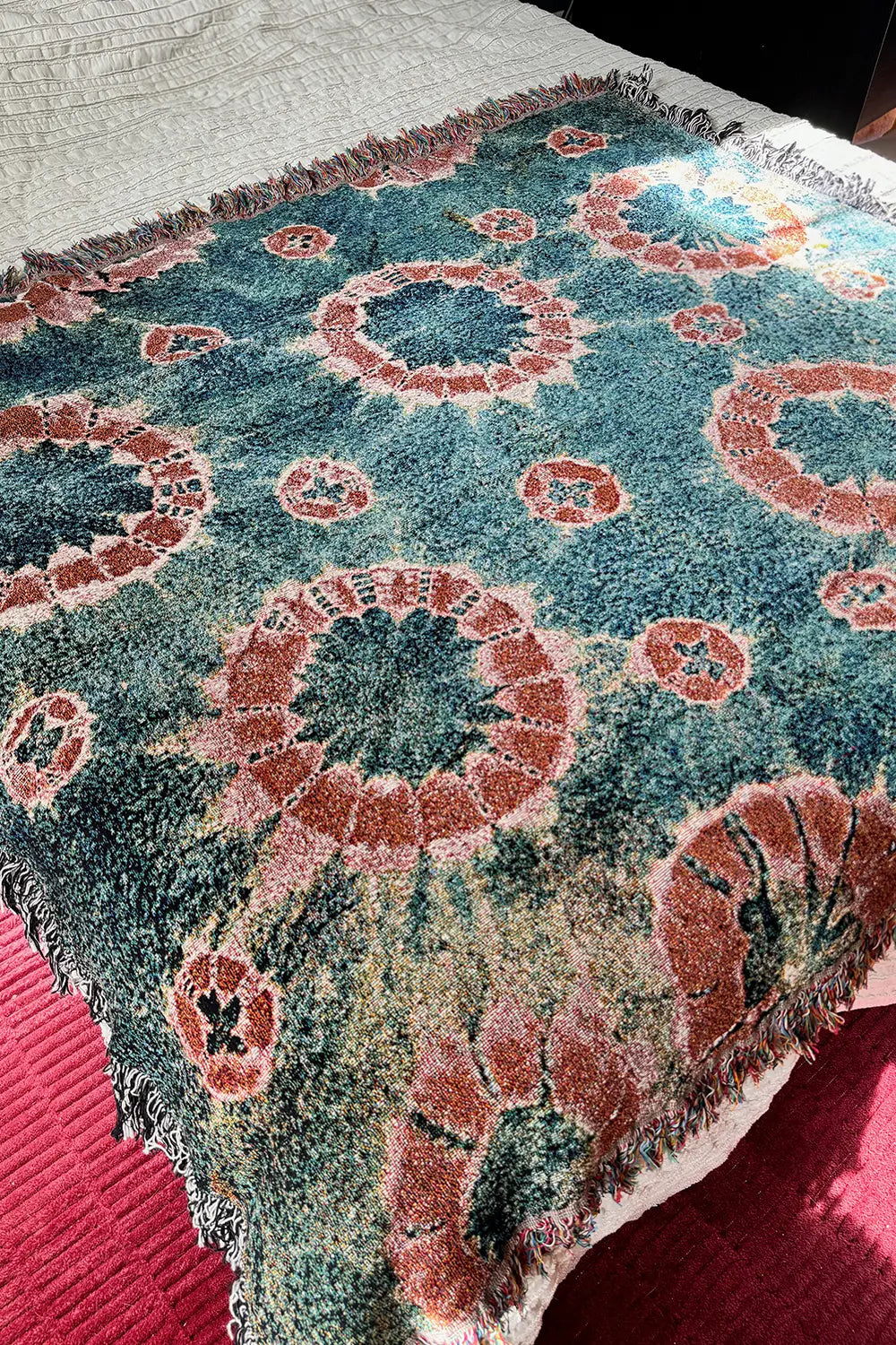 Navy and rust tie-dye woven throw blanket with a vintage-inspired circular pattern.
