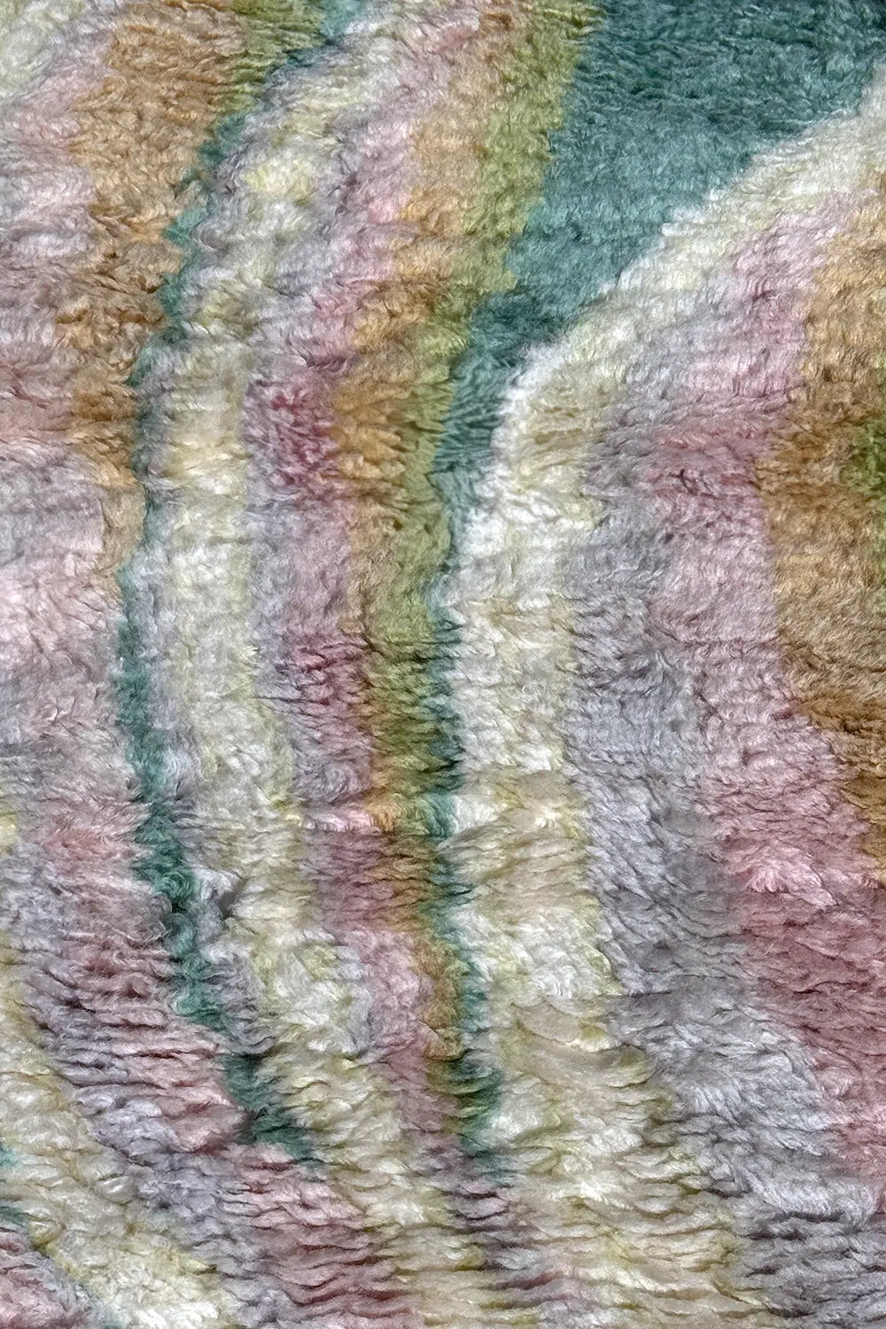 Detailed view of high pile shag rug with sculpted curves in multicolor pastel wool