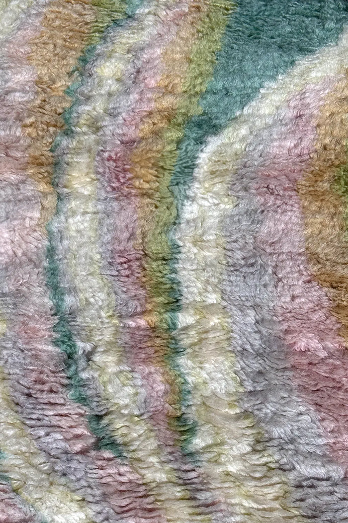 Detailed view of high pile shag rug with sculpted curves in multicolor pastel wool