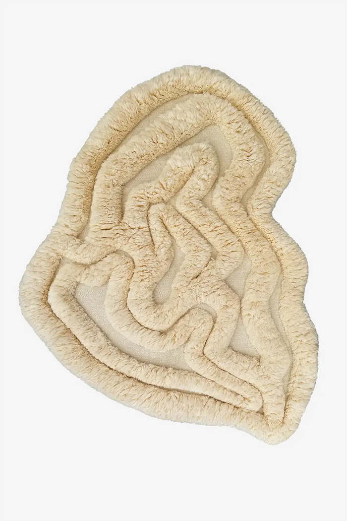 Neutral cream irregular shaped shag rug with soft carved texture and organic silhouette perfect for japandi modern interiors tan

