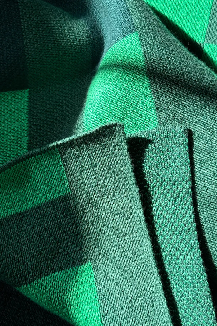 Combed cotton knitted striped throw in deep and vibrant green shades.
