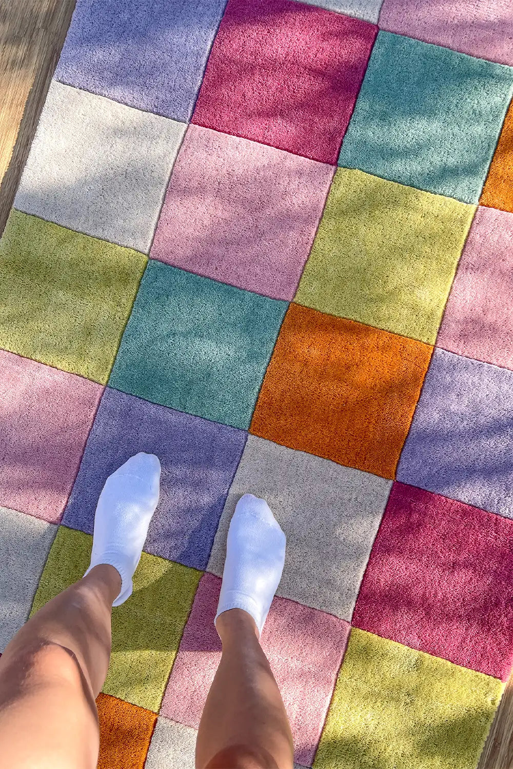 Colorful checkered wool rug with pink, blue, yellow, and orange squares