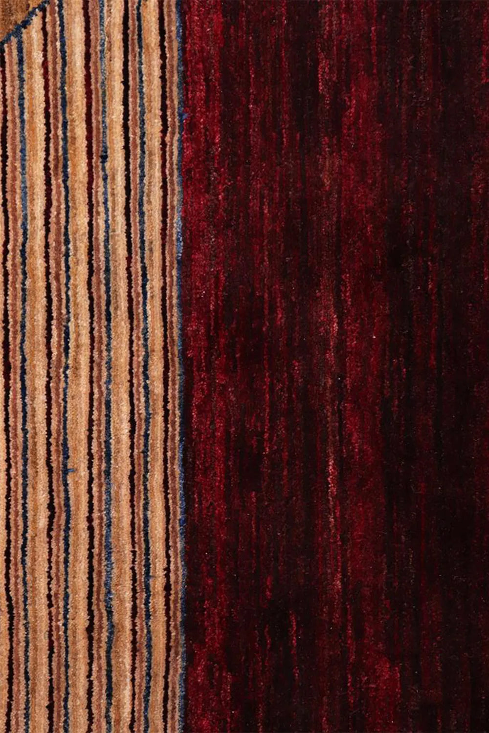 Deep burgundy wool border and neutral-toned striping close-up, emphasizing the artisanal craftsmanship of this hand-knotted rug