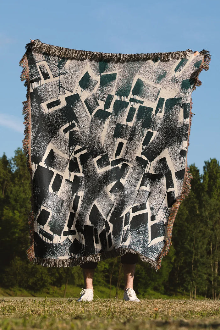 Charcoal geometric cotton throw blanket with modern industrial design.
