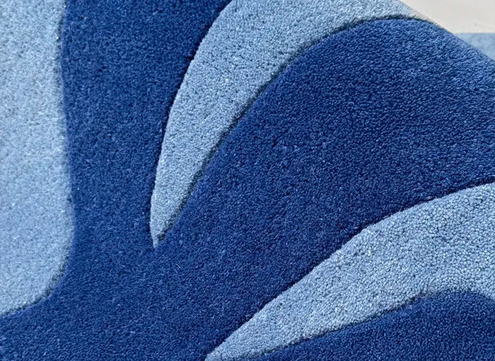 Close-up of a textured blue rug with abstract patterns