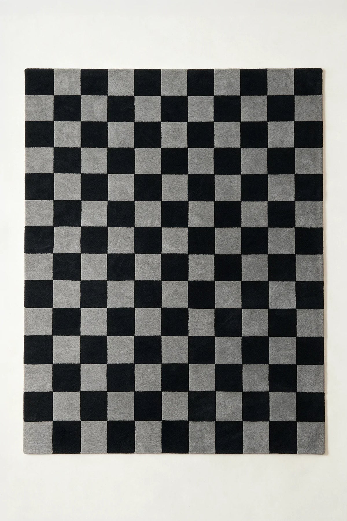 a checkered hand-tufted wool rug in graphite and black, shown flat from above