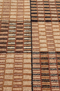 Detailed view of textured brown and tan squares, highlighting the artisanal weaving and bold graphic pattern for luxury and modern homes