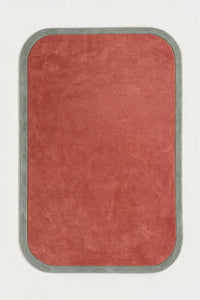 a contour edge hand-tufted wool rug in mist and salmon, shown flat from above