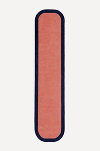 a contour edge hand-tufted wool runner in salmon and navy, shown flat from above