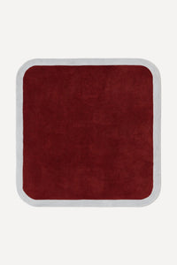a contour edge square hand-tufted wool rug in burgundy and fog, shown flat from above