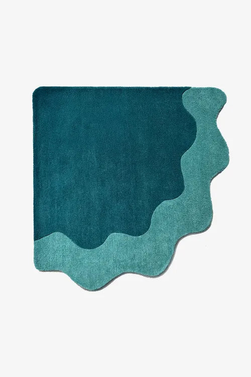 corner shaped teal rug with wavy design on a white background