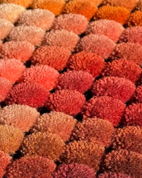 Close-up of rug color samples with multicolored pom-poms