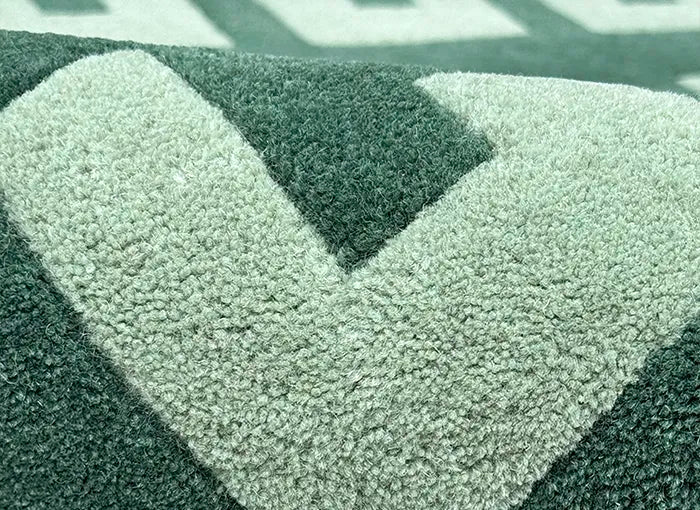 Textured green and gray rug with a geometric pattern