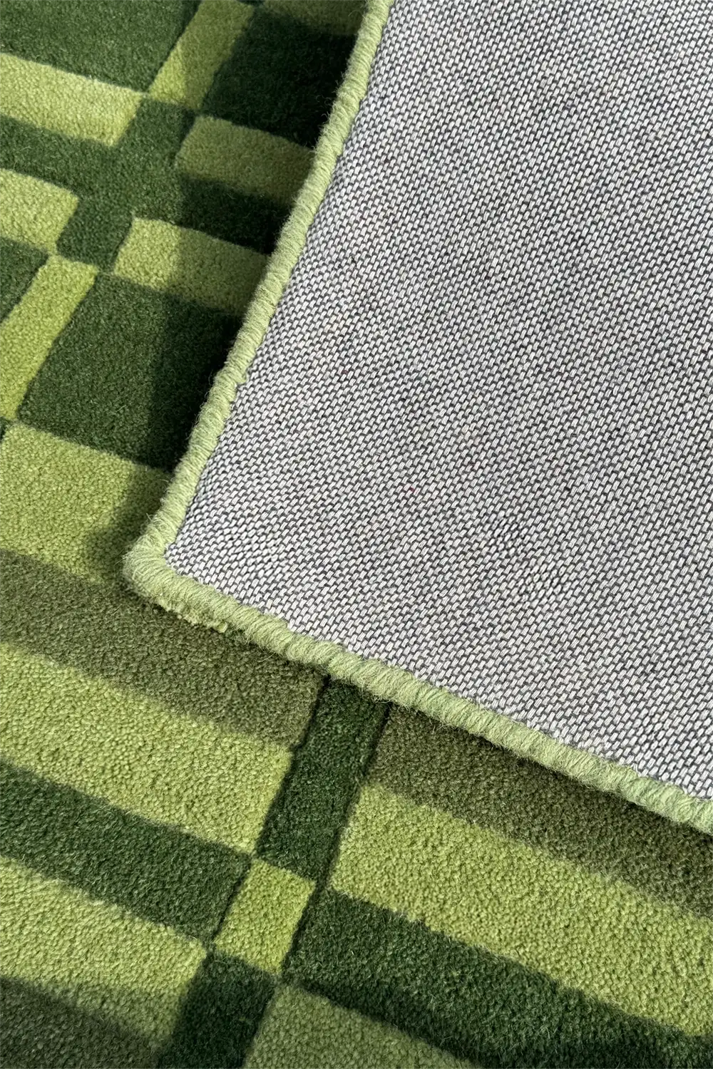 Close-up of olive green striped and checkered patterned rug