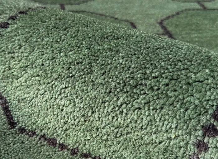 Close-up of a green textured rug with black patterns