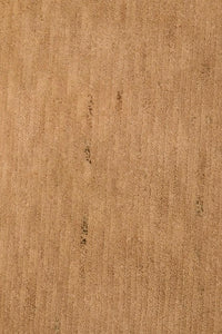 detail view of minimalist tan wool area rug, perfect for earthy living rooms and luxury bedrooms